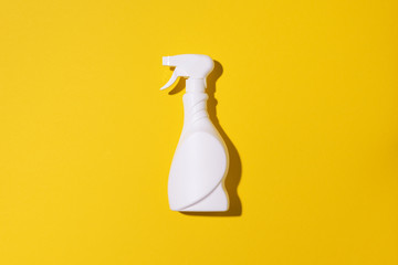 White plastic bottle of cleaning product, household chemicals or liquid laundry detergent on yellow...