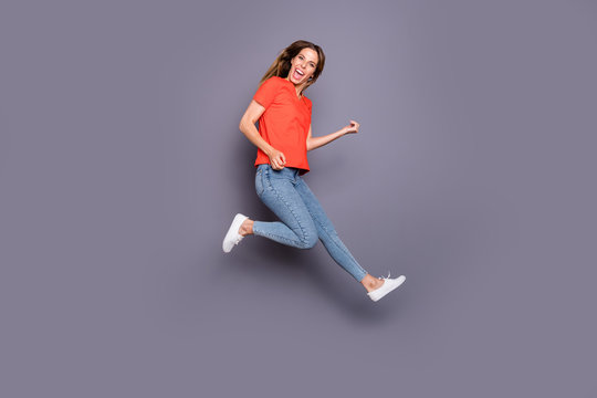 Full size photo of cheerful candid girl teen jump imagine she rock star play guitar sing song wear good looking clothing white sneakers isolated over grey color background