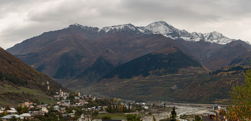 Obraz premium Early morning panoramic view of Mestia village in Svaneti, watchtowers - Koshki and the snow-capped peaks of the mountains in the distance in the mountainous part of Georgia