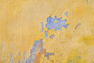 Close-up of an old, scraped wall, yellow painted background, Italy