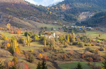 Early morning  view of a small village located at the foot of the mountains against the backdrop of snow-capped peaks in Svaneti in the mountainous part of Georgia