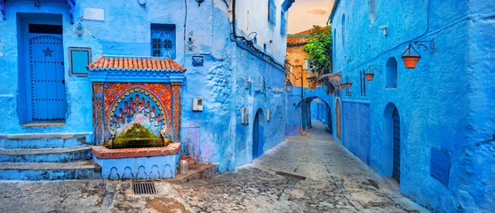 Fotobehang Marokko Fontein met drinkwater op huis gekleurde muur in blauwe stad Chefchaouen. Marokko, Noord-Afrika