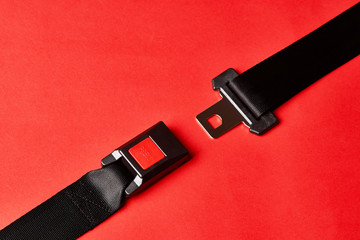Fastened seat belt on red background with copy space, close-up