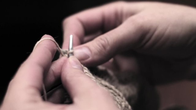Women's hands are knitted on knitting needles. close-up