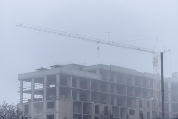 Construction of monolithic concrete construction with construction crane. Housing.