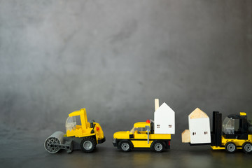 Obraz na płótnie Canvas A set of yellow construction car transports wooden houses