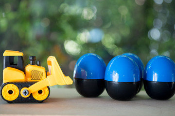Naklejka na ściany i meble Toy bulldozer carry egg toys open inside mini toy to surprise.
