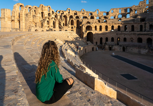 El Jem Roman Amphitheater in Tunisia - Female Tourist Exploring Ancient UNESCO World Heritage Site