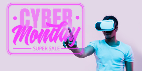 Half-length portrait of young man in VR-set in neon light on pink backgound. The human emotions, black friday, cyber monday, purchases, sales, finance concept. Trendy colors. Negative space.