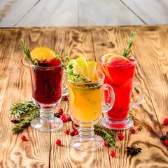 set of three types of hot tea, punch and mulled wine on an old rustic background