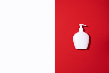 Shampoo and soap bottles on red background. Top view. Flat lay. Copy space.