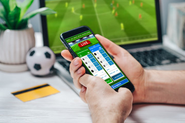 Man making bets using gambling mobile application on his phone