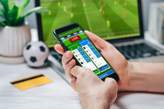 Man Making Bets Using Gambling Mobile Application On His Phone