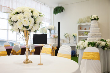 Elegant table with a vase of flowers and the blackboard was set for important guests of the wedding celebrations.