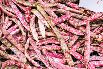 Pink red sugar peas displayed on the vegetable market stall.