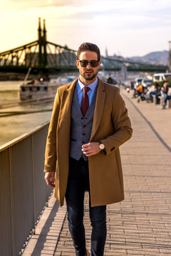 An elegant man standing next to a river
