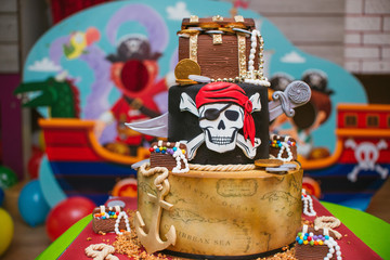 Birthday cake decorated with pirate theme, skulls and treasure maps
