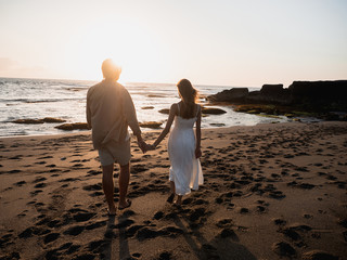 Attractive couple on vacation on the shore of the ocean at sunset time