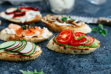 Bruschetta with mushrooms, cucumbers, avocado, radish, salmon and egg