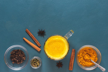 Flat lay with indian drink golden milk on blue background