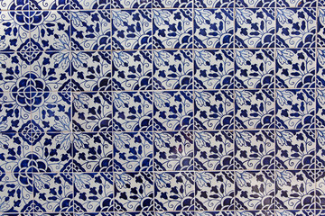 The wall of the house, faced with blue ceramic tiles