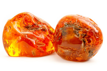 Two transparent pieces of amber on a white background. Natural mineral from fossilized ancient resin of wood. Yellow sun stone  from unique pitch. Chunks of digging. Magic drawing. Crystal. Geology