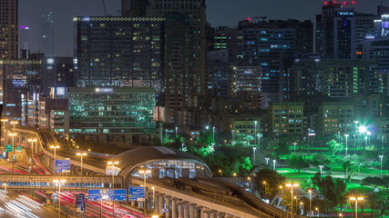 Fototapeta premium Dubai Golf Course with a cityscape of Gereens and tecom districts at the background aerial night timelapse
