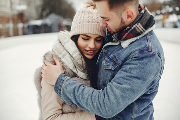 Obraz premium Couple in a winter park. Beautiful girl in a fur coat. Man in a jeans jacket.