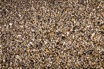 Background of multicolored sea pebbles on the beach. Small color wet stones gravel texture background.