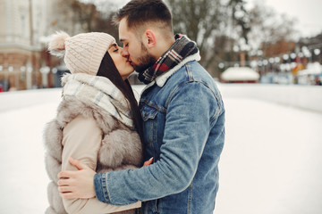 Couple in a winter park. Beautiful girl in a fur coat. Man in a jeans jacket.