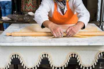 Rolling the dough by hand on the marble table.