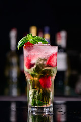 cold strawberry mojito in a dark bar