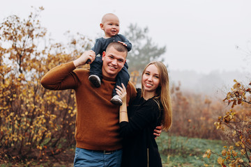 Father, mother and son having fun in the autumn park