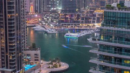 Aerial view of Dubai Marina residential and office skyscrapers with waterfront day to night timelapse