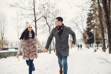Fototapeta na wymiar Couple in a winter park. Beautiful girl in a fur coat. Man in a jeans jacket.