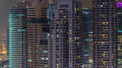 Residential and office buildings in Jumeirah Lake Towers aerial night timelapse in Dubai, UAE.