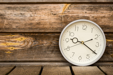 Classic wall clock on the old wooden background