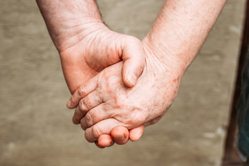 Close-up photo of elderly people holding hands. Hand gestures, loving, care