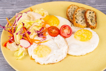 Fried eggs with tomatoes and salad with grenice
