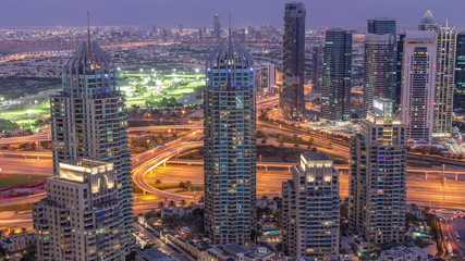 Dubai Marina skyscrapers and jumeirah lake towers view from the top aerial day to night timelapse in the United Arab Emirates.