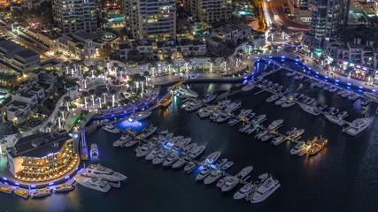 Dubai Marina harbor with modern yachts aerial night timelapse