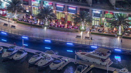 Fototapeta na wymiar Waterfront promenade in Dubai Marina aerial night timelapse. Dubai, United Arab Emirates