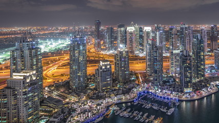 Dubai Marina skyscrapers and jumeirah lake towers view from the top aerial night timelapse in the United Arab Emirates.