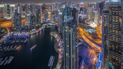 Fototapeta premium Dubai Marina skyscrapers and jumeirah lake towers view from the top aerial night timelapse in the United Arab Emirates.