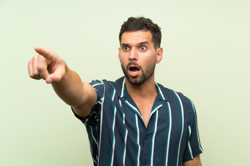 Handsome man over isolated background pointing away