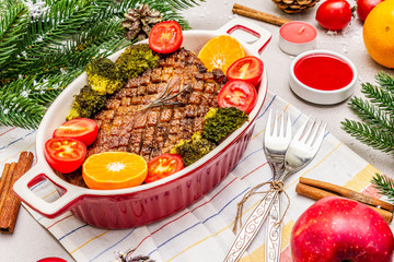 Baked duck breast on the bone with vegetables and sauce. Christmas dinner concept, New Year table setting. Stone concrete background