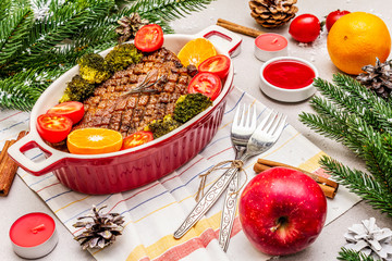 Baked duck breast on the bone with vegetables and sauce. Christmas dinner concept, New Year table setting. Stone concrete background