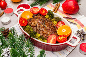 Baked duck breast on the bone with vegetables and sauce. Christmas dinner concept, New Year table setting. Stone concrete background