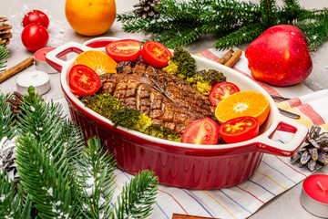 Baked duck breast on the bone with vegetables and sauce. Christmas dinner concept, New Year table setting. Stone concrete background