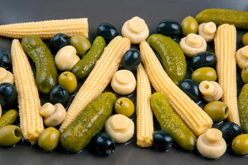 Olives, pickled cucumber, mushrooms and corn in a salad on a plate. food and vegetables. diet and weight loss